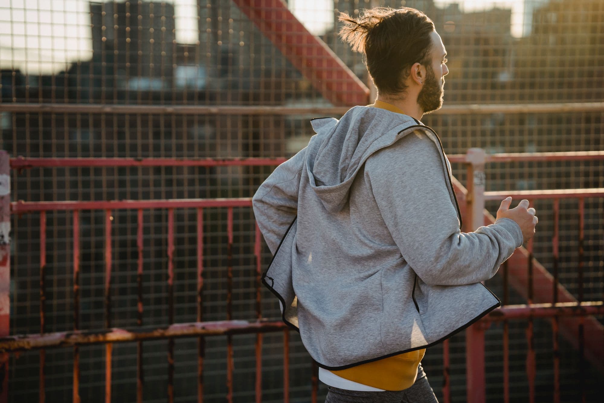 Man running across a city bridge at first light